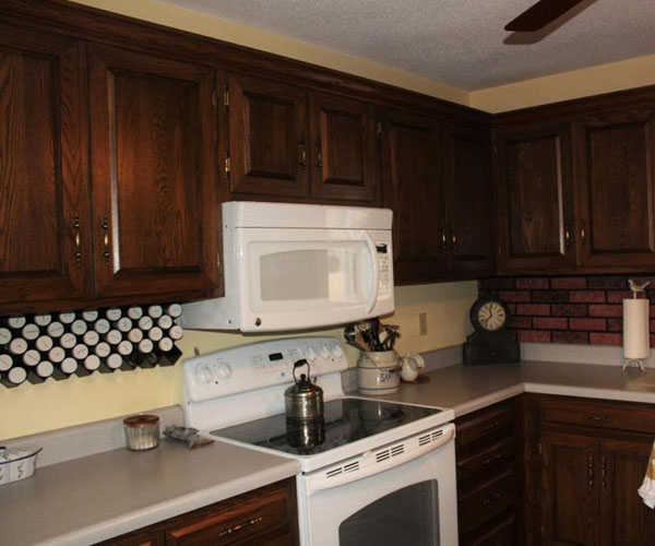 Before — Kitchen remodel with white cabinets, butcher-block island, and stainless appliances